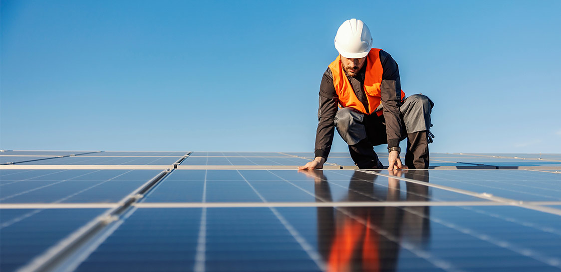 C'est une photo d'un homme entrain d'installer des panneaux photovoltaïques.